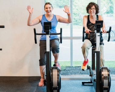 Women training on cardio bikes at The Tribe